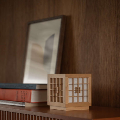 Japanese Wood Table Lamp "Honoka" used as a handcrafted wabi sabi accent lamp on a wooden shelf in a mid-century-modern room.
