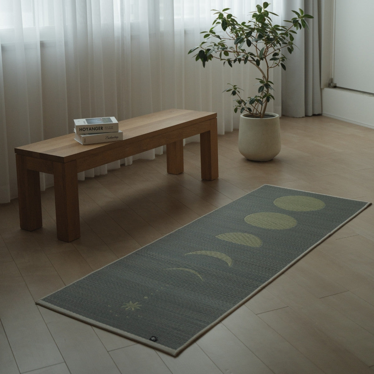 Japanse Tatami Yogamat "Maan" Grijs geplaatst op een moderne houten vloer in een minimalistische woonkamer voor een natuurlijke, rustgevende ruimte voor thuisoefeningen.