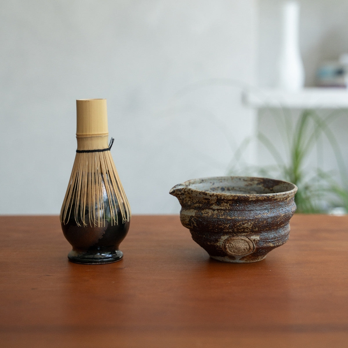 Bol à matcha Sakigake noir et fouet à matcha japonais Zen posés sur une table, pour sublimer votre rituel matcha matinal