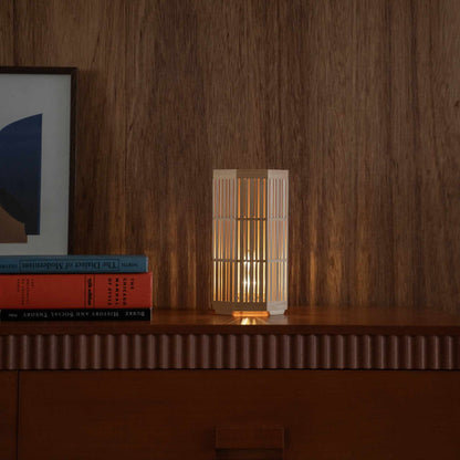 Glowing Japanese wood table lamp "Kagayaki" serving as a warm accent lamp on a wooden console in a mid-century modern living room setting.
