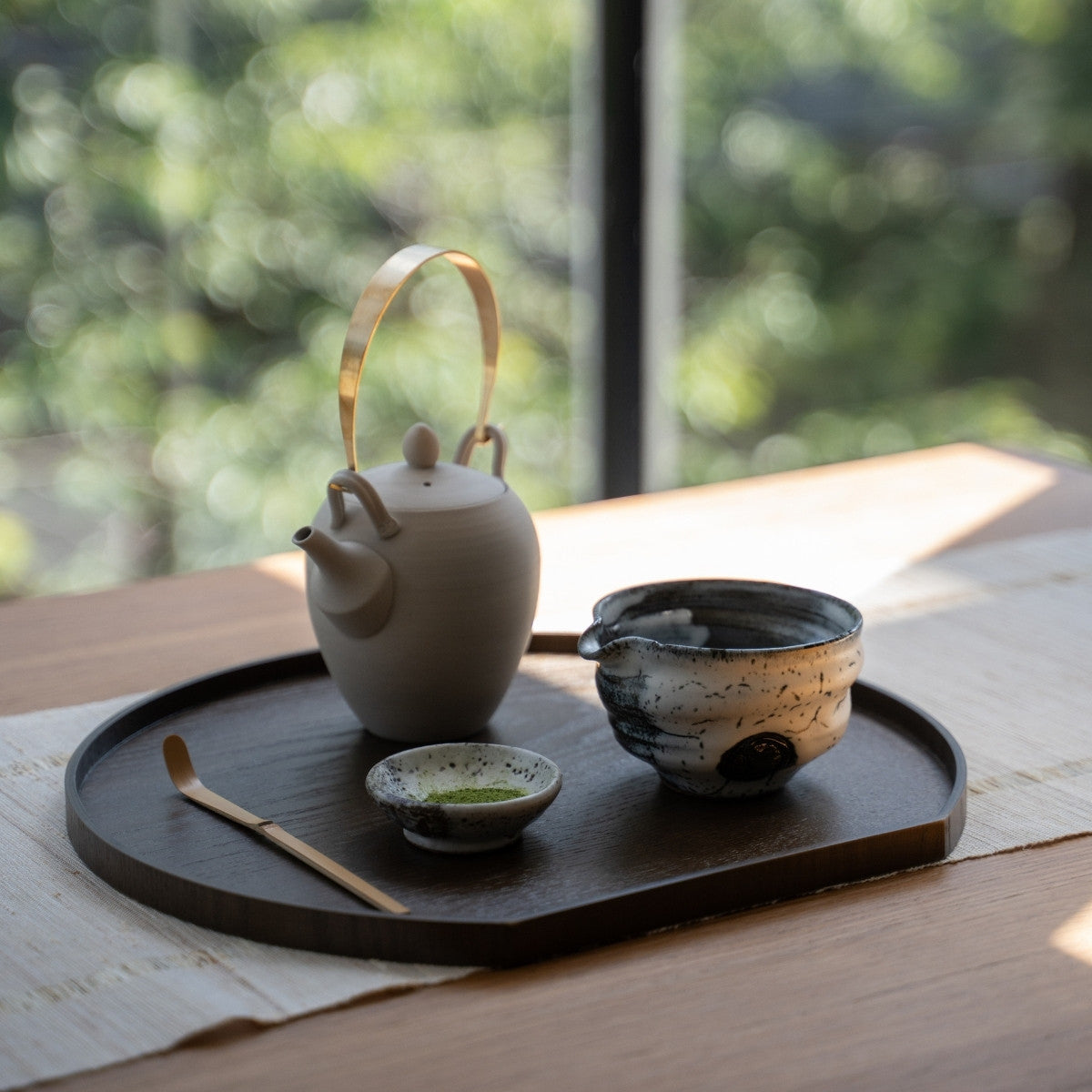 Creative Cloud Japanese matcha bowl with spout and a teapot on a tray by a window, for casual matcha latte making