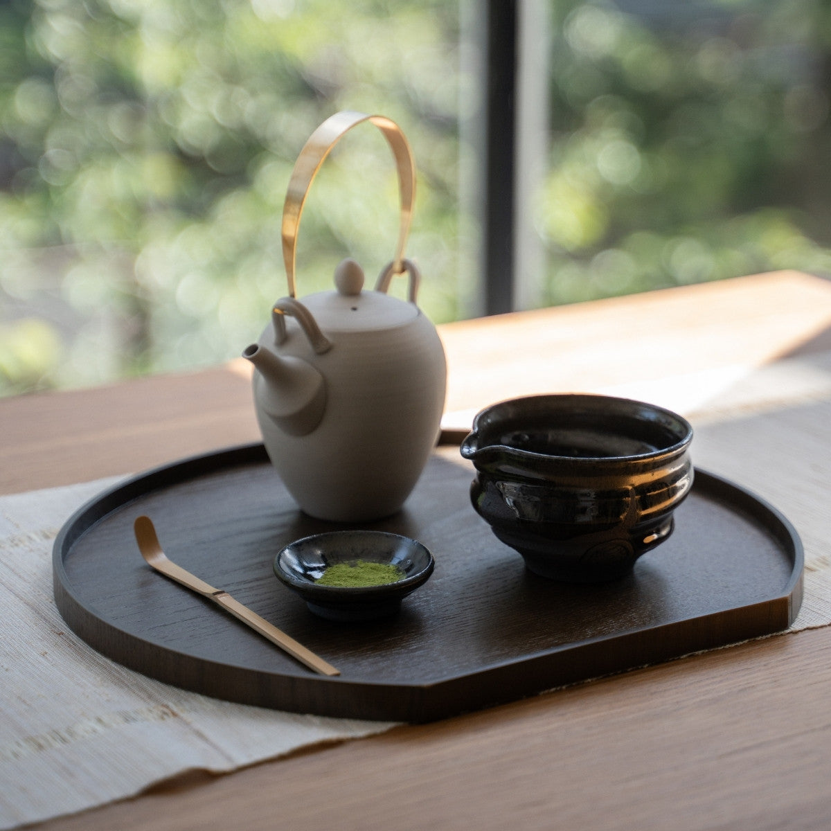 Dignity Blue matcha-skål med tud og tekande på en bakke ved et vindue, perfekt til autentisk piskning eller afslappede lattes