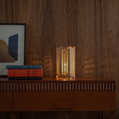 "Lit Japanese wood table lamp \"Towaru\" wirft geometrische Schatten als Ambientelampe auf einem Mid-Century-Modern-Konsolentisch."