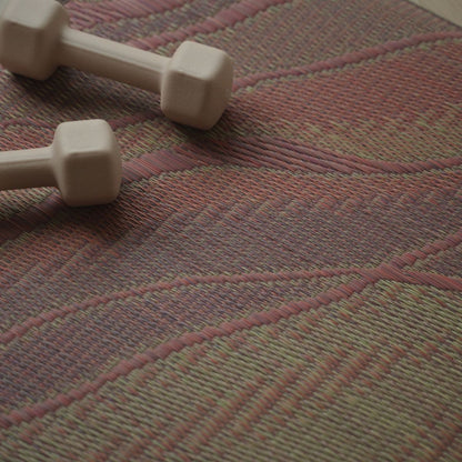 Detailed weave of the Japanese Tatami Yoga Mattress "Marble" Pink with small dumbbells, showing authentic tatami texture.