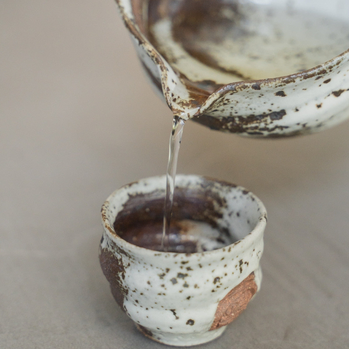 Zui Japanese sake set featuring a katakuchi carafe and cups on a tray, for a mature luxury experience by the side table
