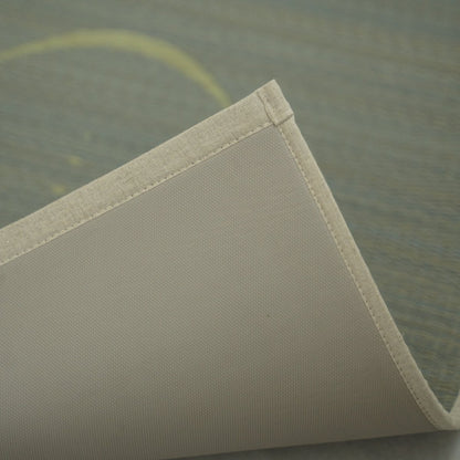 Grijze Japanse Tatami Yogamat "Maan" licht opgetild aan de hoek, waardoor de schone randen en de antislip TPE-onderkant voor een veilige training zichtbaar worden.