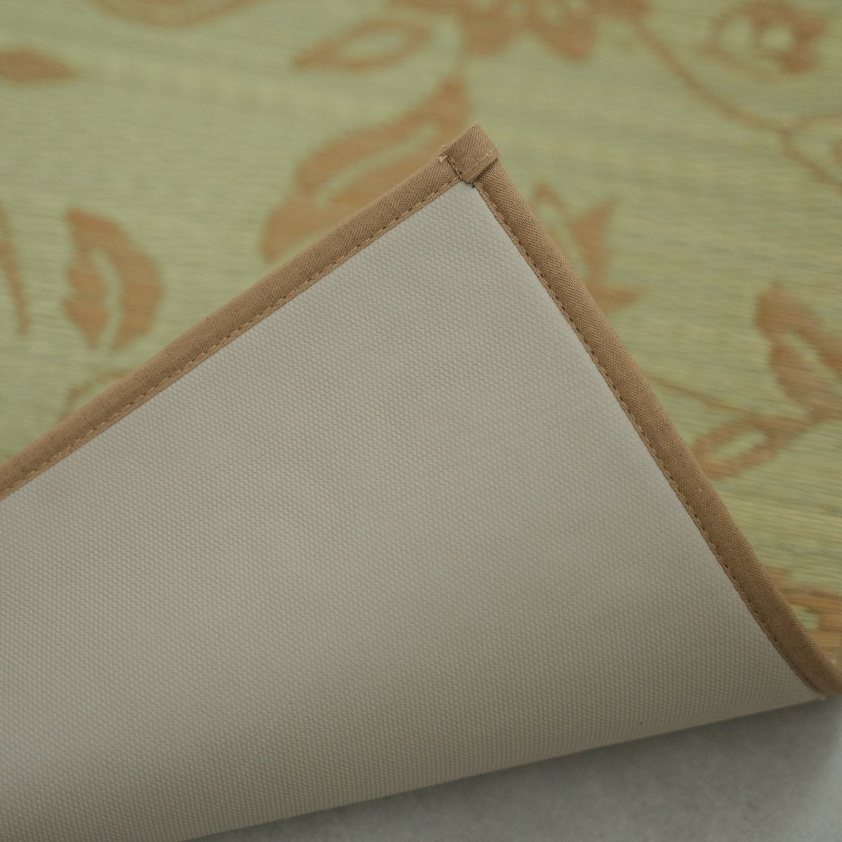 Close-up of the corner of a Japanese Tatami Yoga Mattress "Sarasa" Beige, flipped to show the non-slip TPE backing and cotton border.