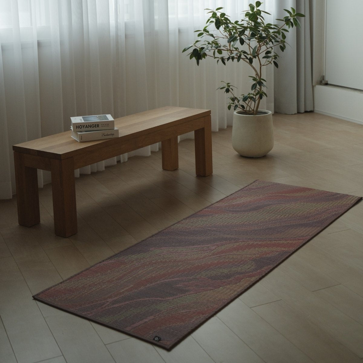 Japanese Tatami Yoga Mattress "Marble" Pink laid on a light wooden floor in a minimalist living room for home meditation.