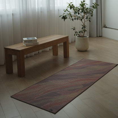 Japanese Tatami Yoga Mattress "Marble" Pink laid on a light wooden floor in a minimalist living room for home meditation.