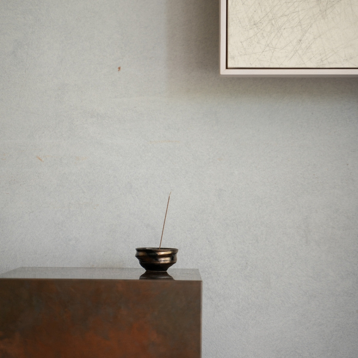 Gouden en zwarte Japanse wierookbrander op een rustieke houten console, voor een serene sfeer tijdens een dagelijkse yogaroutine.