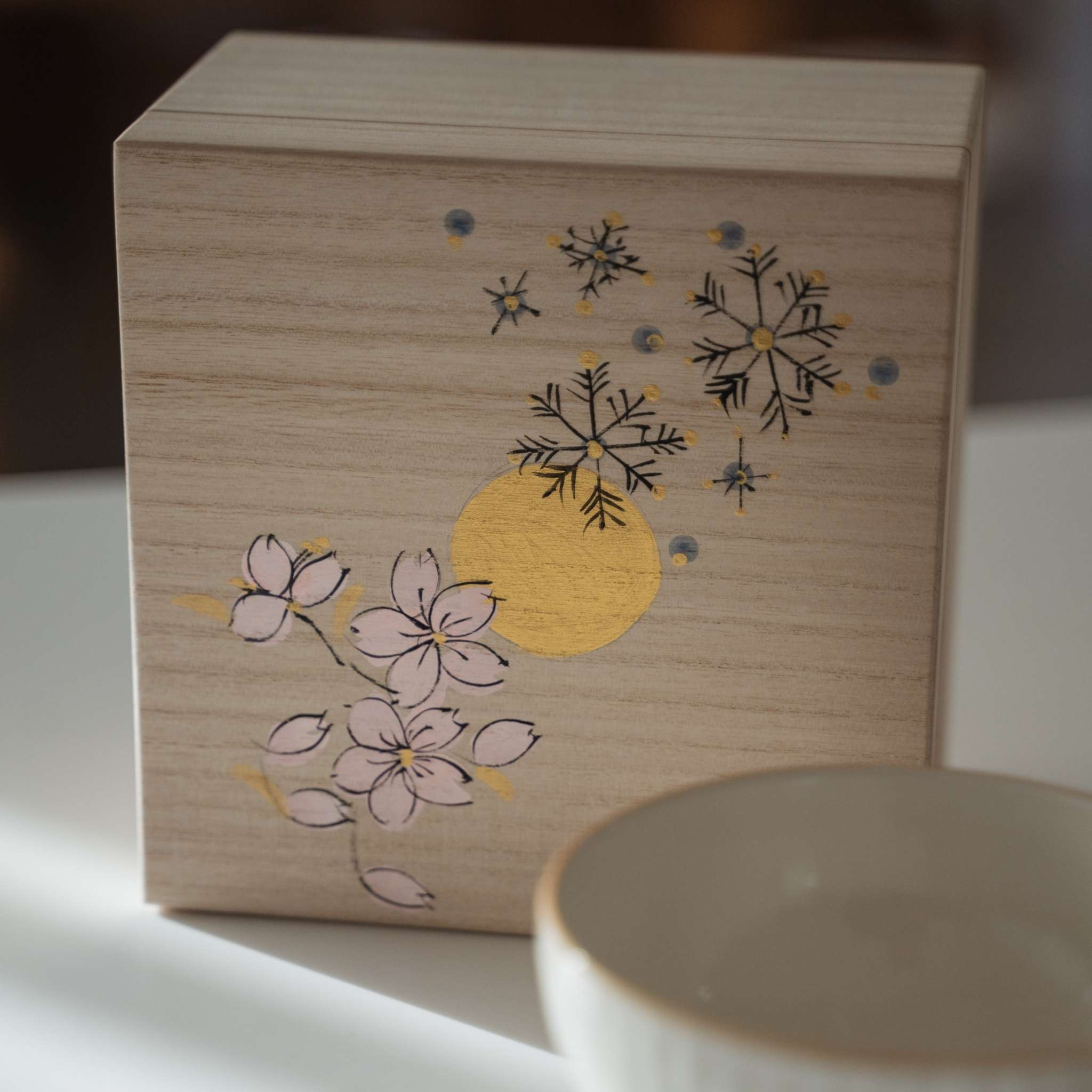 Håndmalet paulownia træ gaveæske til en japansk matcha skål med illustrationer af sne, måne og blomster.