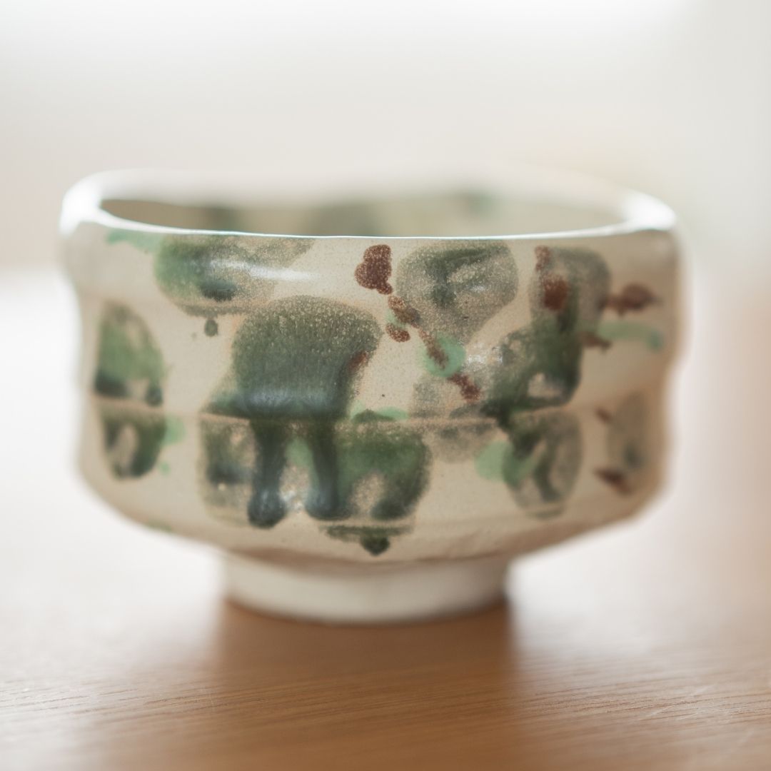 Tæt på detalje af "Skov" matcha-skålen, der fremhæver keramikens ru, taktile tekstur og den kunstneriske spredning af grøn glasur, der ligner naturens løv.