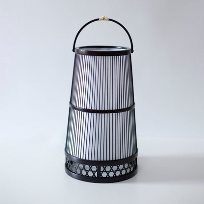 "Lampe japonaise fabriquée avec l'art du bambou de Shizuoka, vieux de 800 ans. De délicates lamelles de bambou créent des motifs complexes, diffusant une lumière chaude à travers le papier japonais."