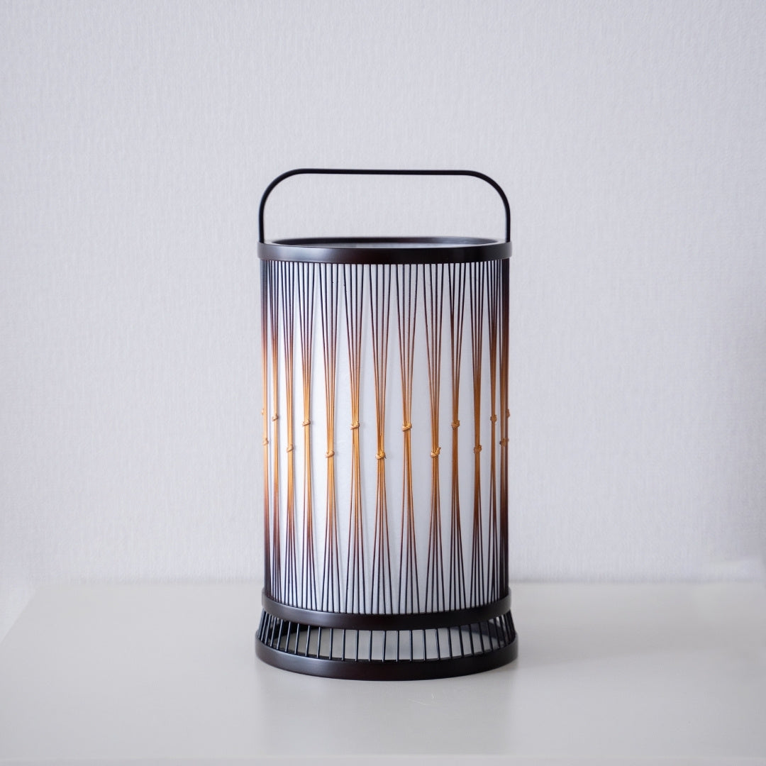 Eine japanische Bambus-Stehlampe auf einem weißen Tisch.