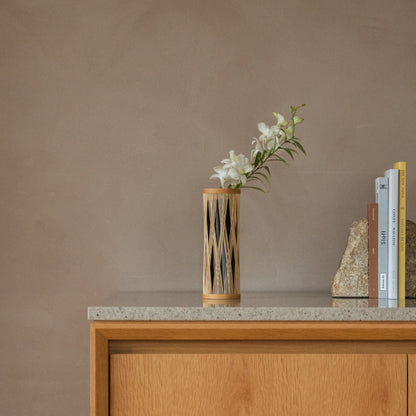 Vase à fleurs en bambou japonais « Branche entrelacée » marron, mis en scène dans un intérieur.