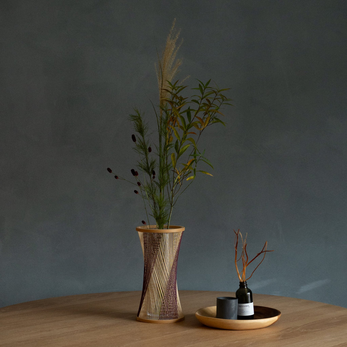 Japanese Bamboo Flower Vase "Fleeting Moment" in brown & purple styled in a dining room setting, dining scene view.