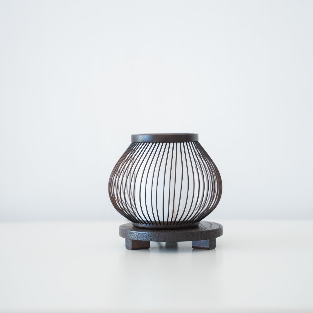 "Minimalistische bamboe tafellamp op een tafel in een slaapkamer in Japandi-stijl, met 800 jaar vakmanschap uit Shizuoka, Japan."
