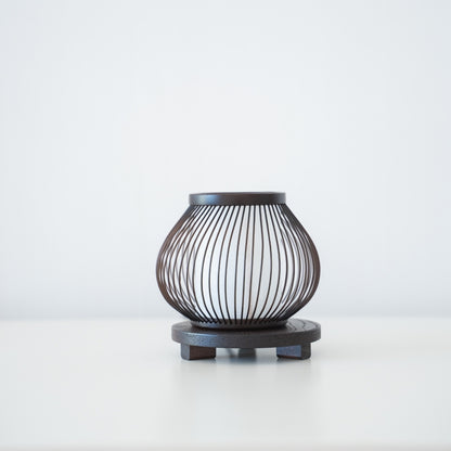 "Minimalistische bamboe tafellamp op een tafel in een slaapkamer in Japandi-stijl, met 800 jaar vakmanschap uit Shizuoka, Japan."