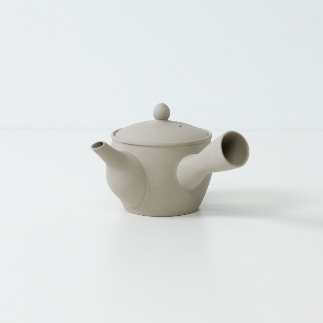 Sidevisning af en hvid ler fuyo japansk tekande, der viser tudens og sidehåndtagets design