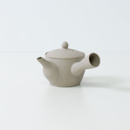 Sidevisning af en hvid ler fuyo japansk tekande, der viser tudens og sidehåndtagets design