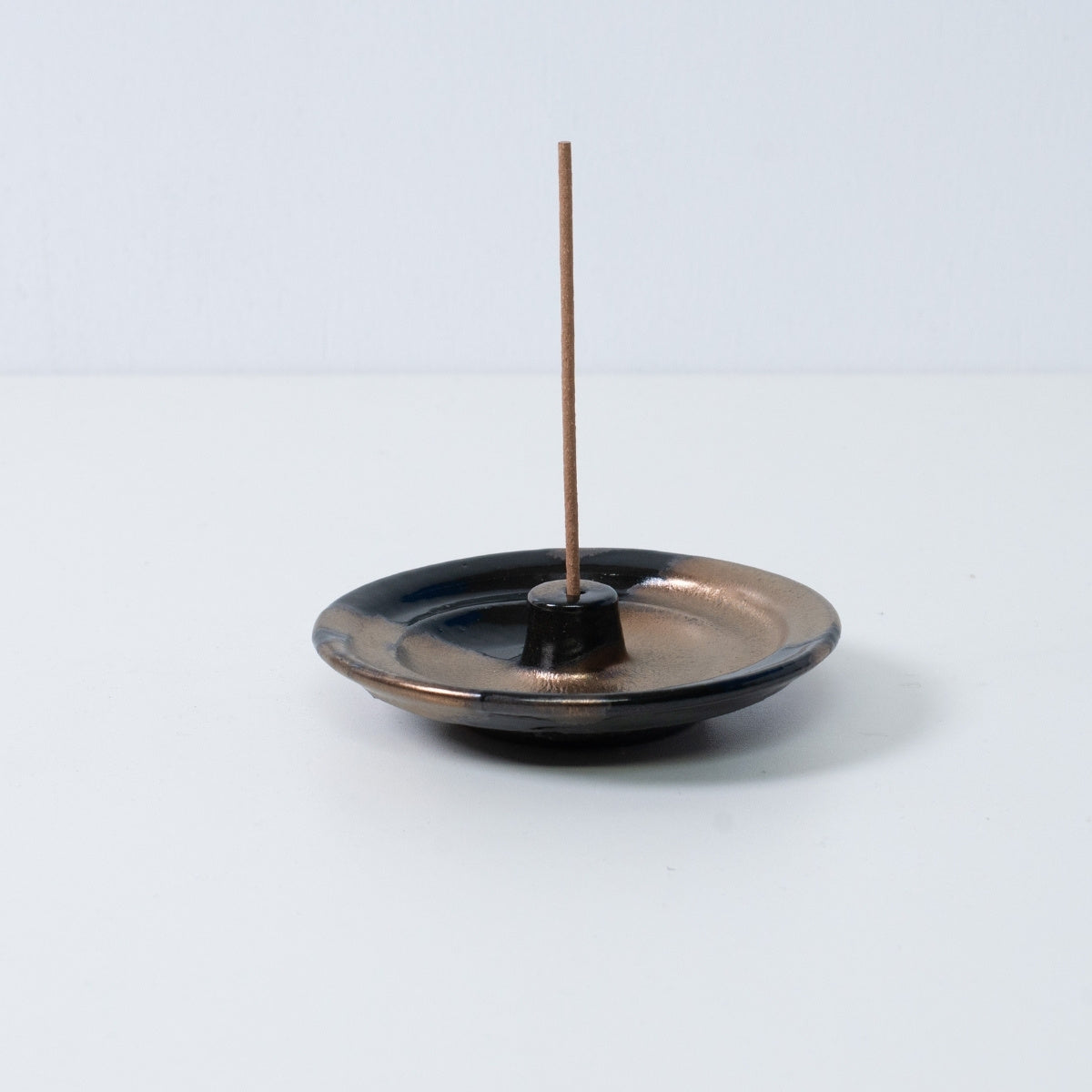 Japanischer Räucherkegelhalter "Zen" aus Keramik mit einem Loch für eine Räucherstäbchen, gold-schwarze Glasur.