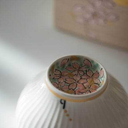 Opslået hvid matcha-skål med lyserøde kirsebærblomster malet indeni foden.