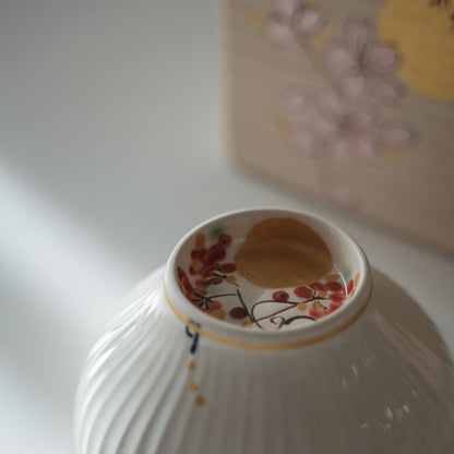 Omvendt hvid porcelæns matcha-skål med håndmalet måne- og efterårsfrugt-design indeni foden.