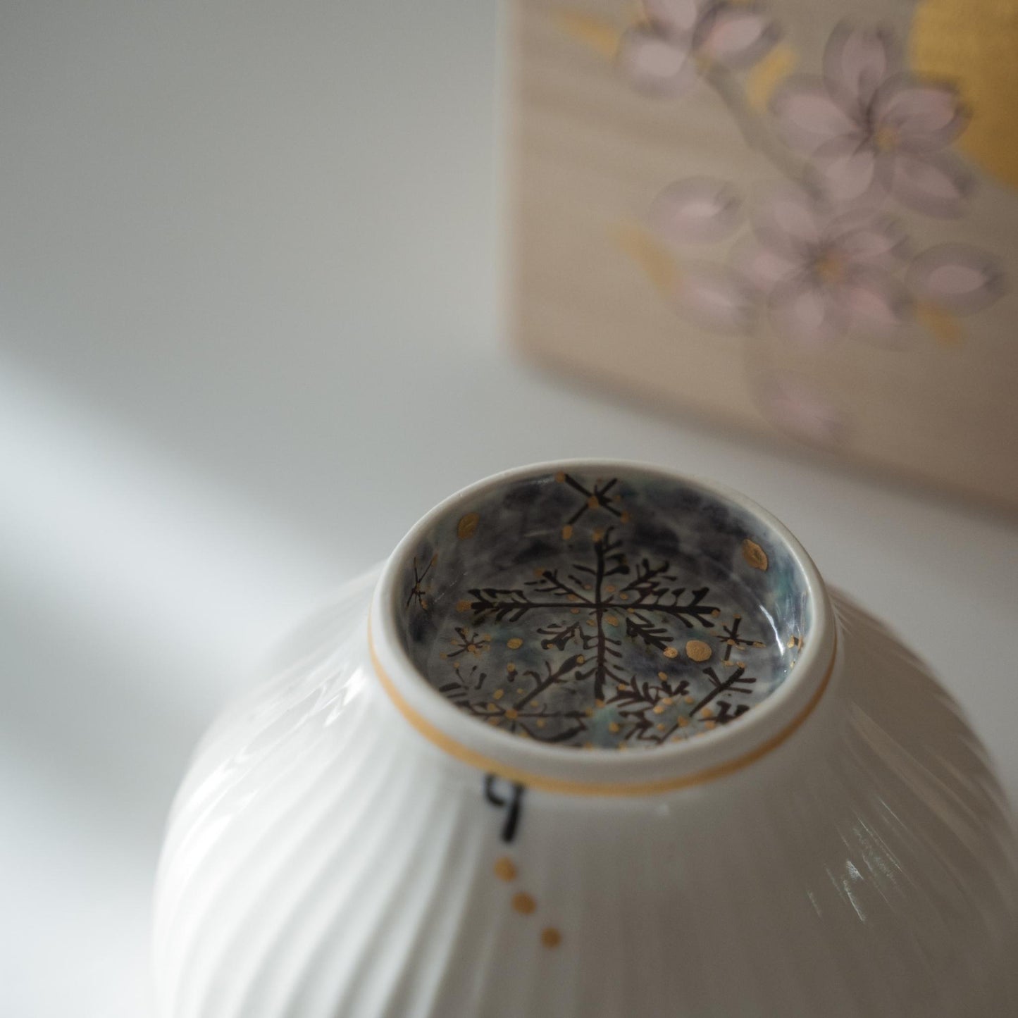 Overside ned japansk matcha-skål, der afslører et blåt snefnugdesign malet inde i bundringen.