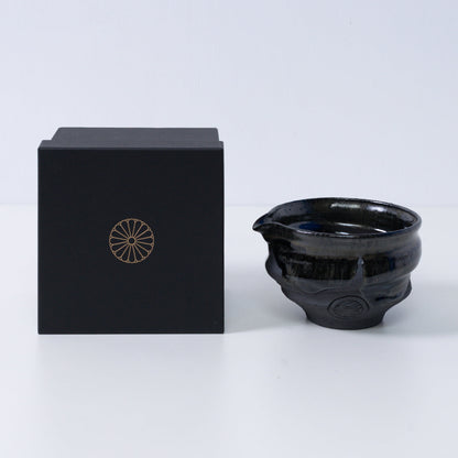 Japanese matcha bowl with spout "Dignity Blue" pottery beside a black gift box with a gold chrysanthemum crest, from Japan.