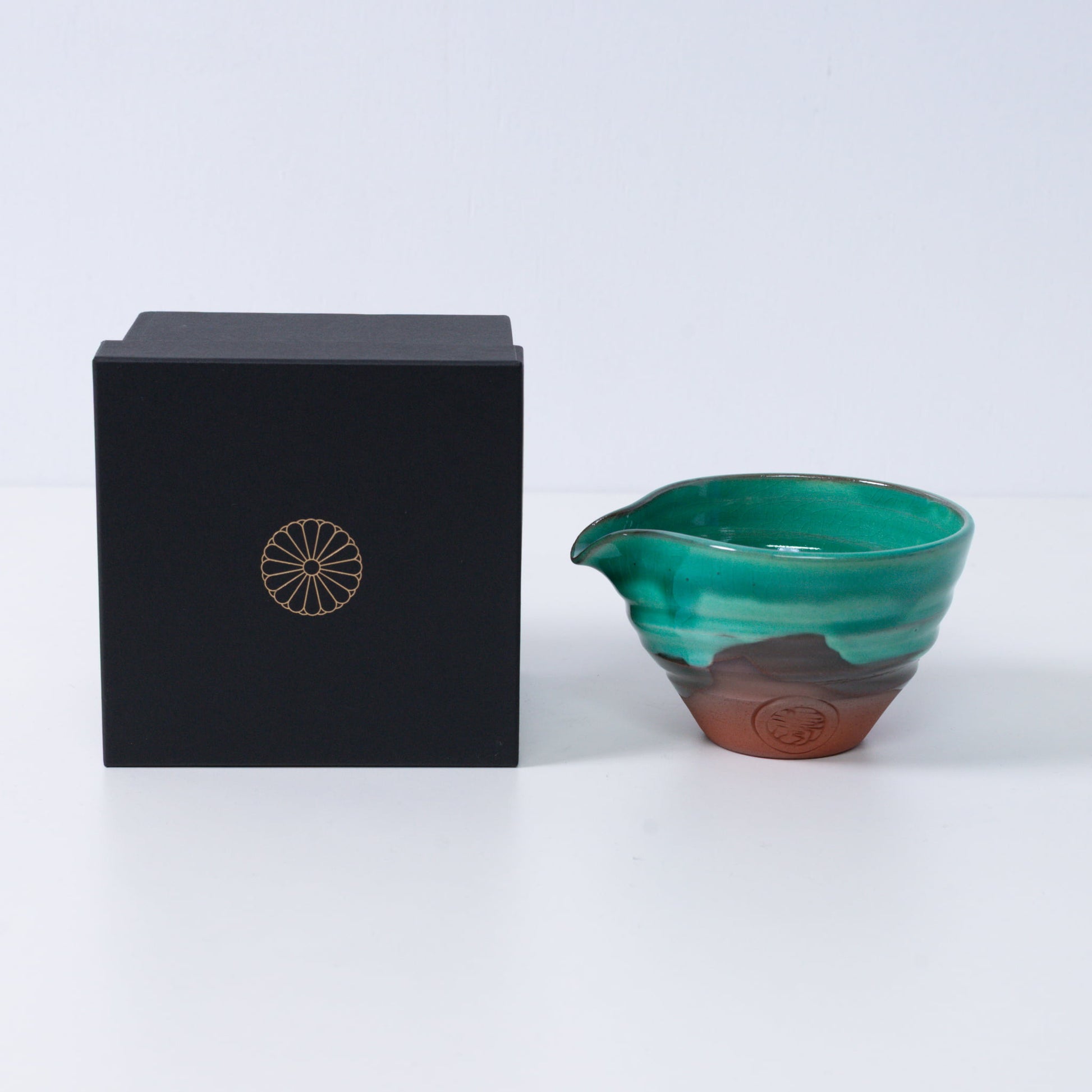 Japanese matcha bowl with spout "Emerald" pottery beside a black gift box with a gold chrysanthemum crest, made in Japan.