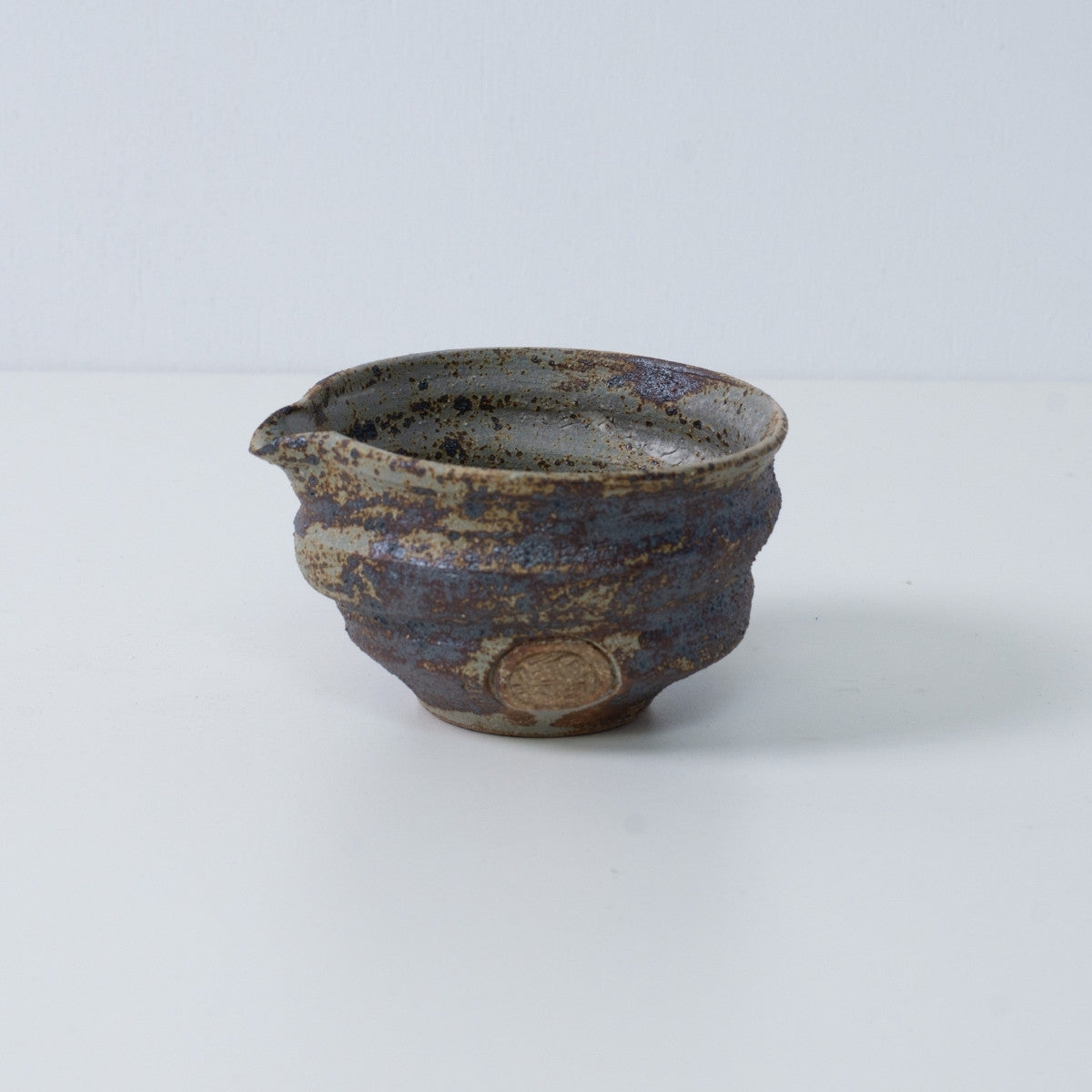 Japansk matcha-skål med tud, Sakigake keramik fra Japan, med en rustik brun tekstureret glasur og et kunstnersegl.