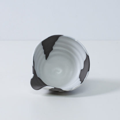 Inside view of a Japanese matcha bowl with spout "White Flow" pottery, showing the white and black glaze, made in Japan.