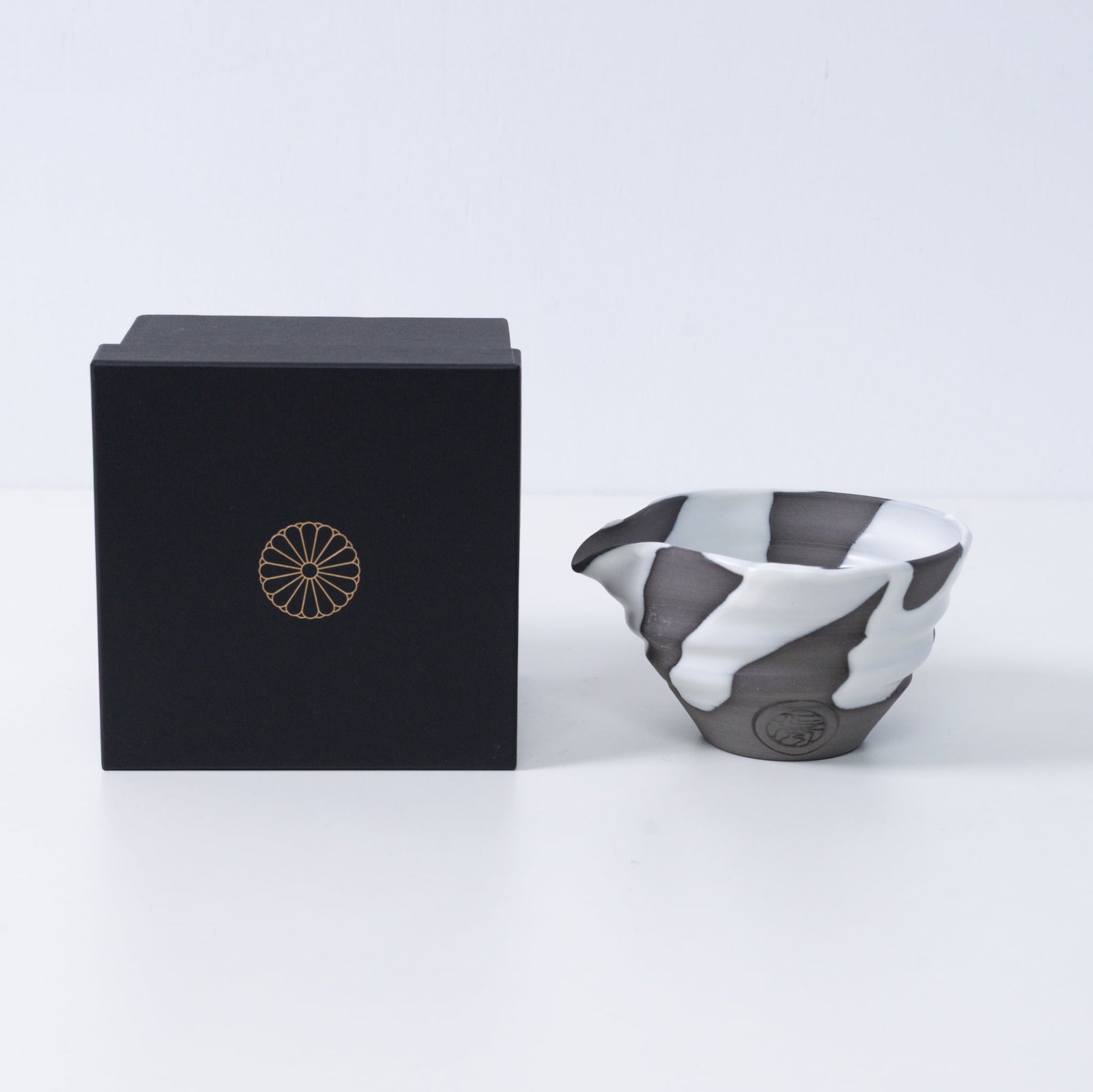 Japanese matcha bowl with spout "White Flow" pottery next to a black gift box with a gold chrysanthemum crest, made in Japan.