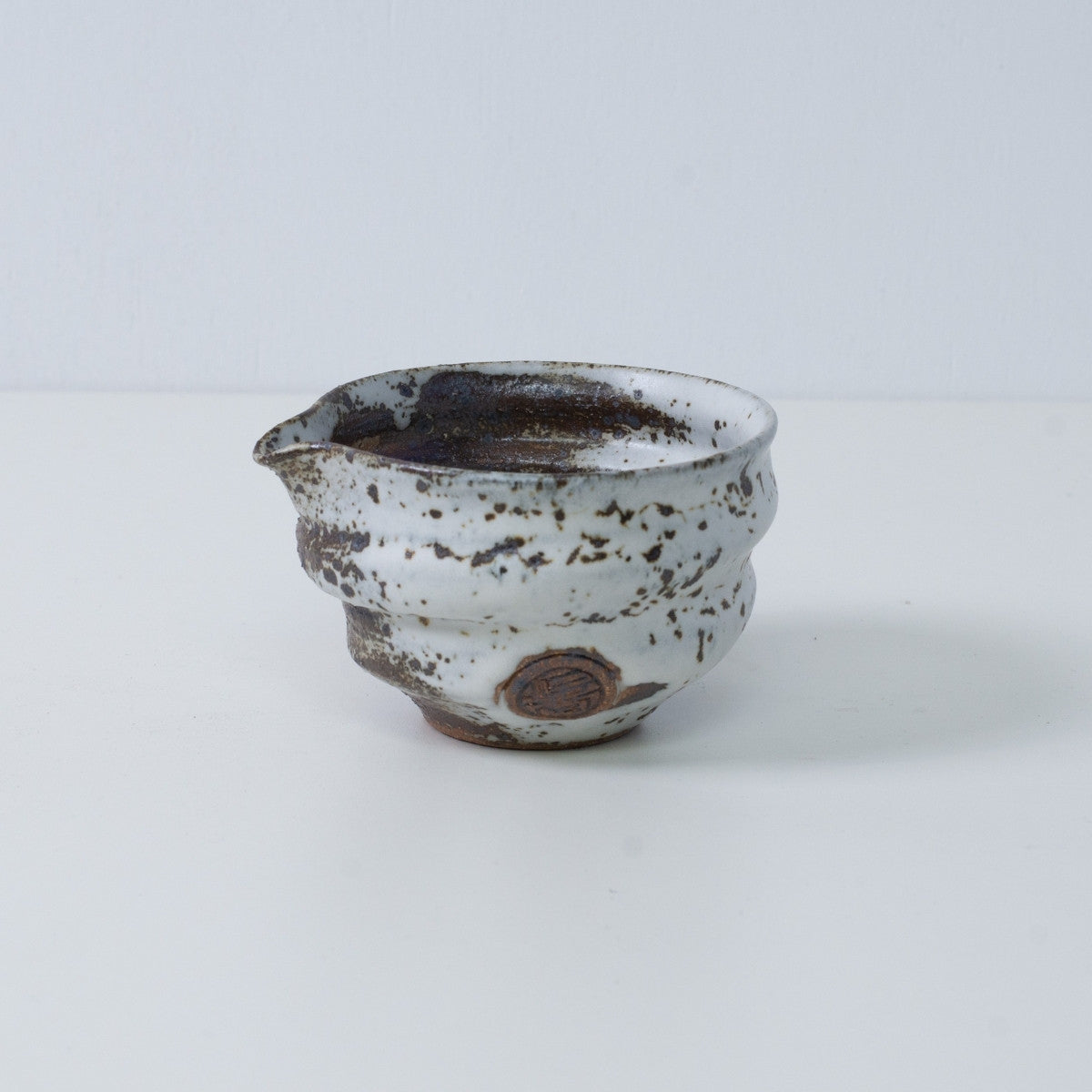 Japanese matcha bowl with spout "Zui" pottery from Japan, with uneven white glaze and an engraved artisan seal.