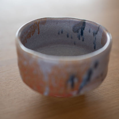 Ophængt, let vinklet billede, der viser det indre og ydre af den japanske matcha-skål i navy og rød. 