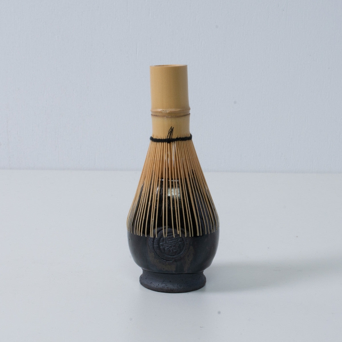 Deep blie Japanese matcha whisk stand "Dignity Blue" pottery chasen stand with a bamboo tea whisk placed on top, made in Japan.