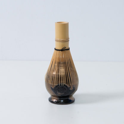 Support en céramique noir et or pour fouet à matcha japonais "Zen", avec fouet à thé en bambou posé dessus, fabriqué au Japon.