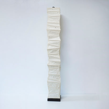 Vue complète d'une lampe japonaise en papier washi, haute et incurvée de manière aléatoire, sur fond blanc