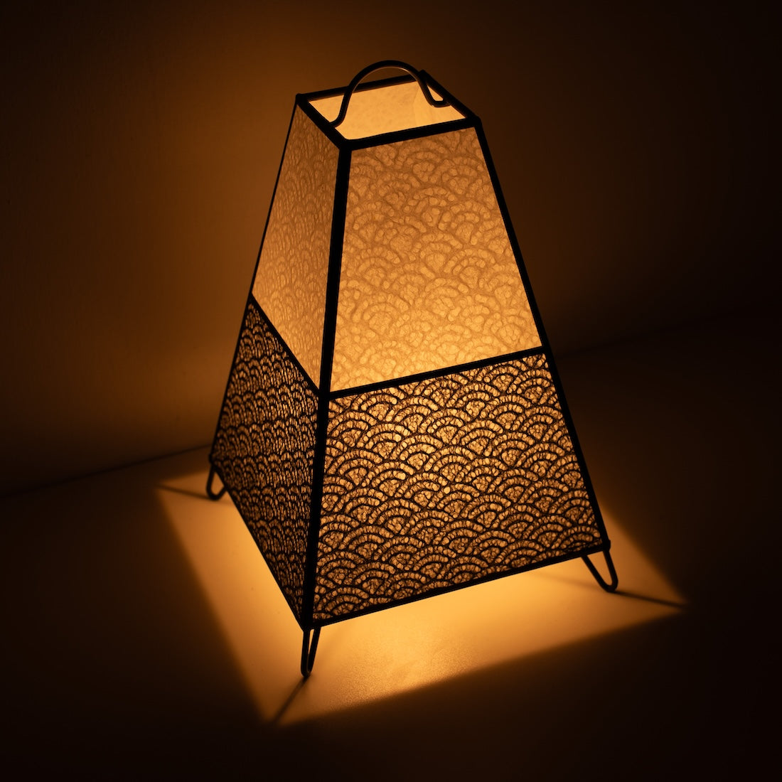 "Japanse Papieren Vloerlamp KURA Klein, monochroom, Mino Washi papier - schuin aanzicht van verlichte papieren lamp op draadpoten."
