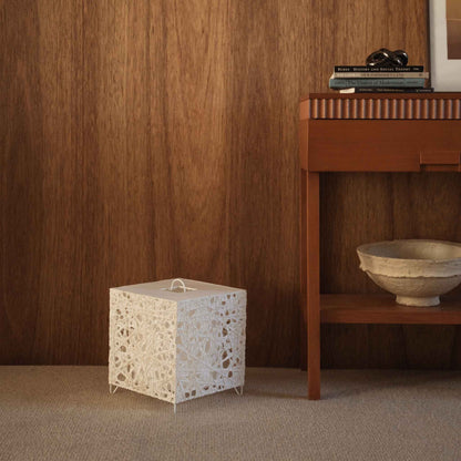 Lampe sur pied blanche en papier, forme cube, Me-Look 03, posée sur un tapis beige devant un mur en bois sombre dans un salon