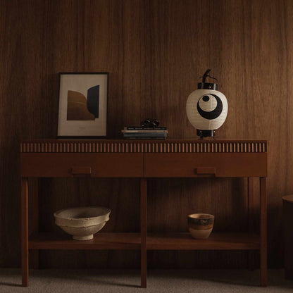 Onverlichte witte Japanse papieren lantaarn 'maan en ster' model geplaatst op een houten console tafel met ingelijste kunst als interieurdecoratie