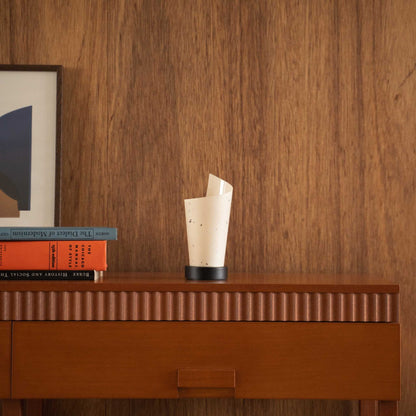 "Lampe de table japonaise non allumée « Maki » en papier, de forme roulée, stylisée sur une console en bois de style moderniste du milieu du siècle."
