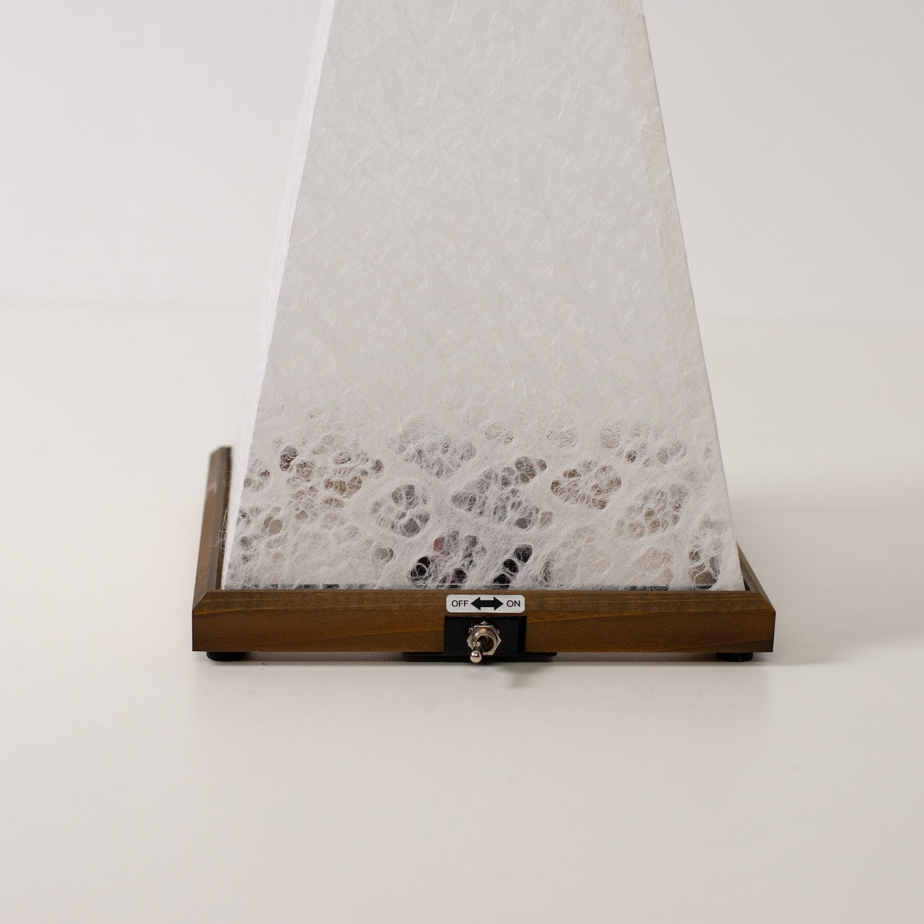 Japanese Paper Table Lamp "Mini Akari", white, wood - close-up of wooden base and toggle switch for the cordless lamp.