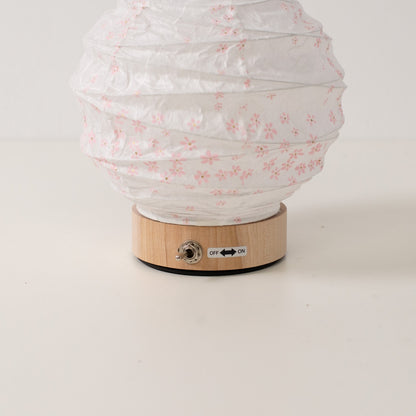 Japanese Paper Table Lamp "Yuhi" Sakura, white, close-up of the wooden base and toggle switch for the cordless lamp.