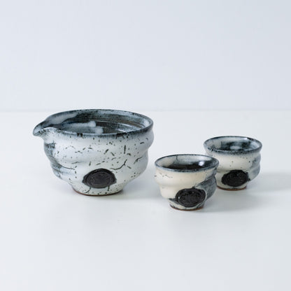 White and black Japanese sake set "Creative Cloud" pottery featuring a katakuchi sake carafe pitcher and two small sake cups, made in Japan.