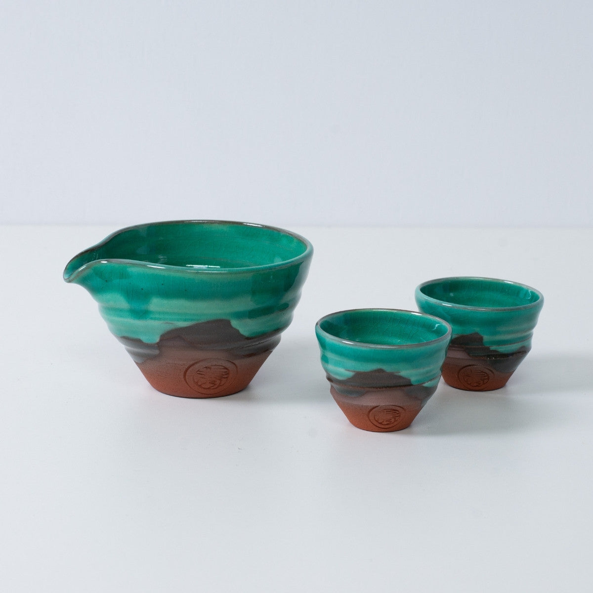 Emerald green and orange Japanese sake set "Emerald" pottery featuring a katakuchi sake carafe pitcher and two small cups with red clay.