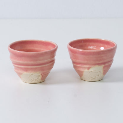 Two Japanese sake cups ochoko "Omuro Cherry" pink pottery from Japan, featuring an engraved artisan seal on the front.