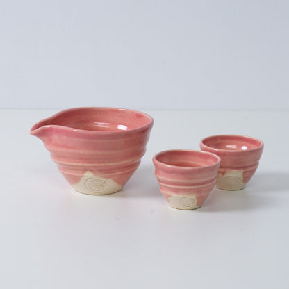 Pink Japanese sake set "Omuro Cherry" pottery featuring a katakuchi sake carafe pitcher and two small sake cups, made in Japan.