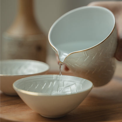 Handgeschöpft aus einer weißen japanischen Sake-Kanne in eine zarte Guinomi-Tasse auf einem Holztablett, was ein besonderes Abendessen aufwertet.