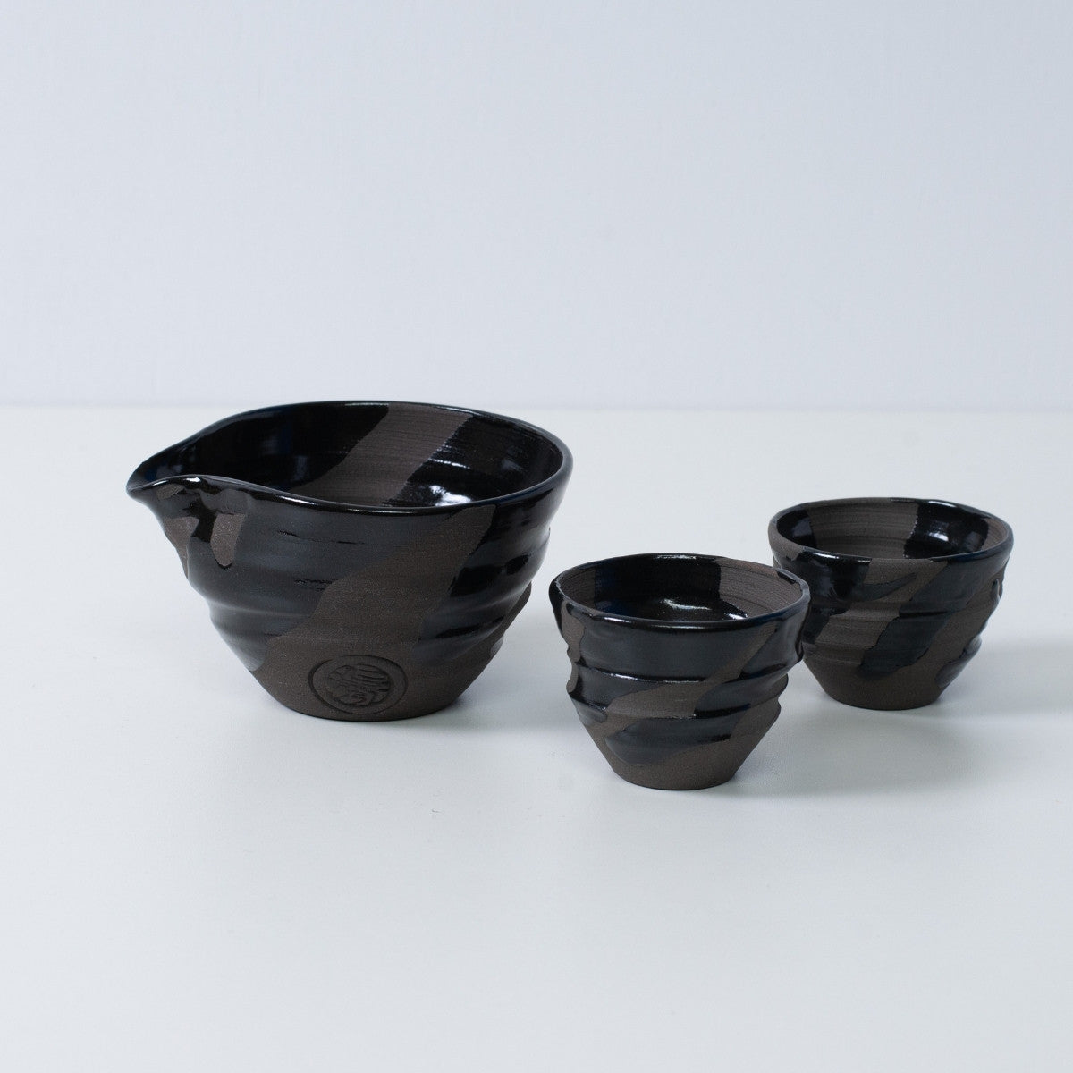 Japansk sake-sæt "Sumi Black" keramik med en katakuchi sake-karaffel og to små sake-kopper, lavet i Japan.